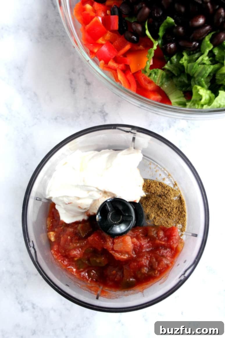 The 3-ingredient taco salad dressing being poured over the salad ingredients.