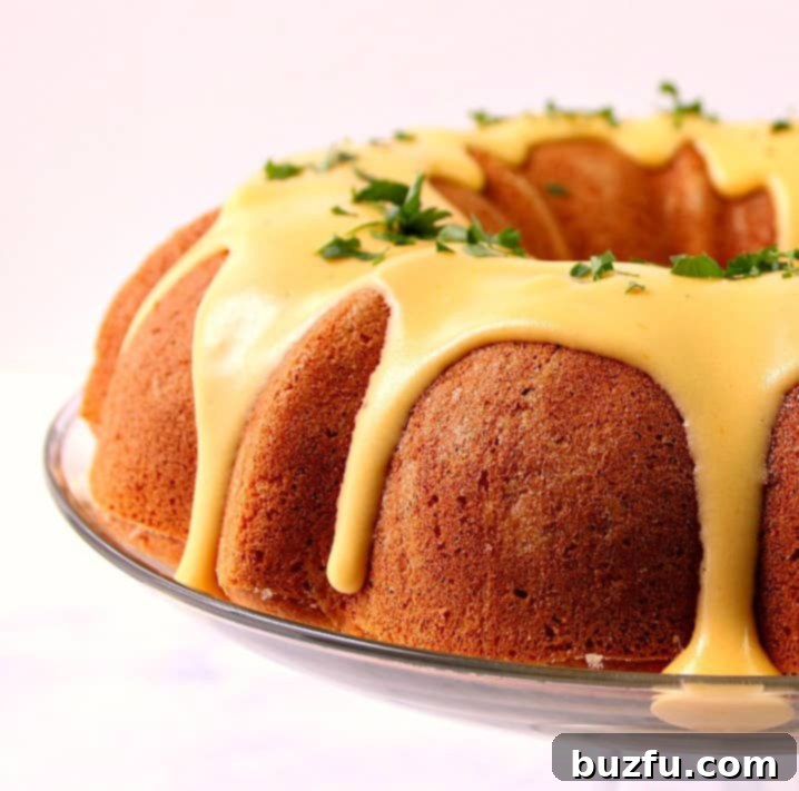 Side shot of a golden cornbread bundt cake drizzled generously with a rich, golden nacho cheese sauce, ready to be served.