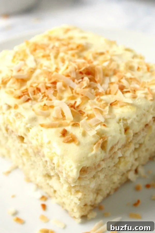 Irresistible Coconut Pineapple Cake A beautifully decorated slice of Coconut Pineapple Cake on a plate, showing its tender crumb and creamy frosting.