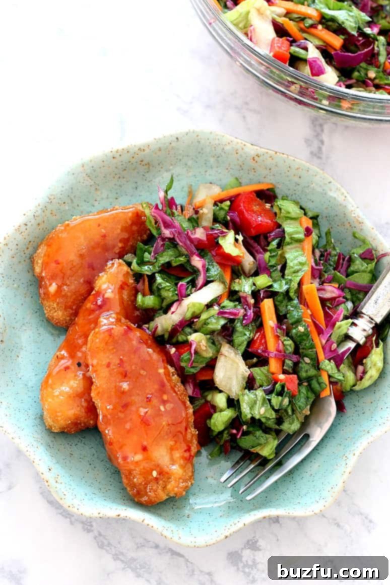 Asian Chopped Salad with Garlic Sesame Vinaigrette Recipe served with Sweet Chili Pollock Tenders - quick and easy weeknight dinner idea with a ton of flavor! Vibrant Asian Chopped Salad with Garlic Sesame Vinaigrette paired with crispy Sweet Chili Pollock Tenders on a plate, a perfect quick weeknight dinner idea.