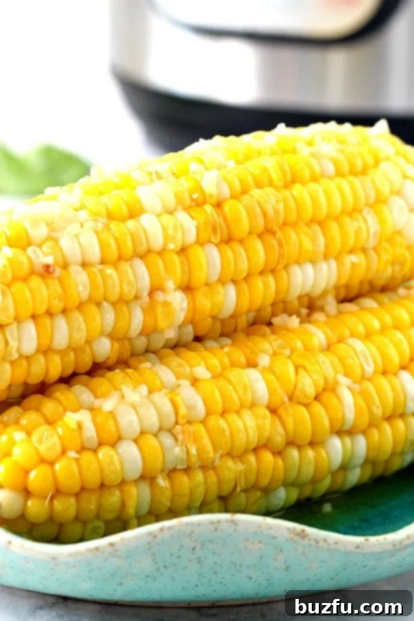 Instant Pot Corn on the Cob on a plate, garnished with fresh herbs and a hint of melted butter.