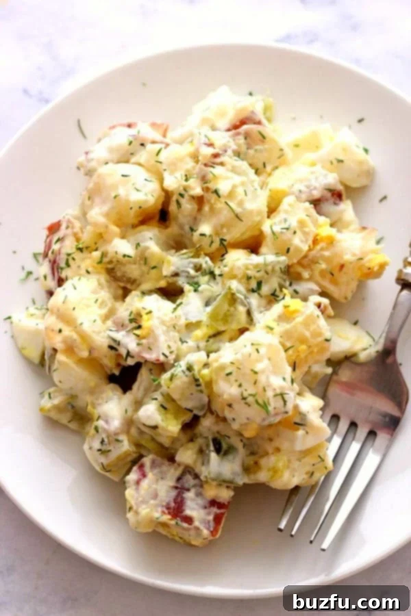 Dill Pickle Potato Salad on white plate with fork.