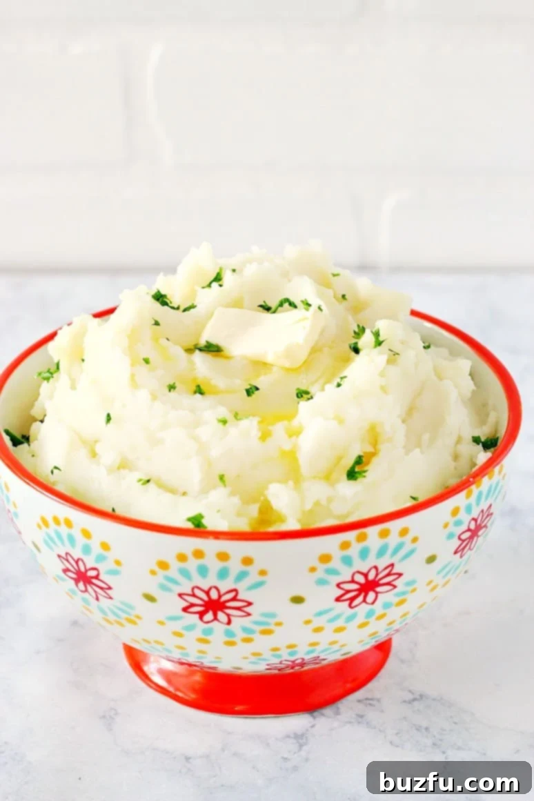 Mashed potatoes with a piece of butter in a bowl with red rim.