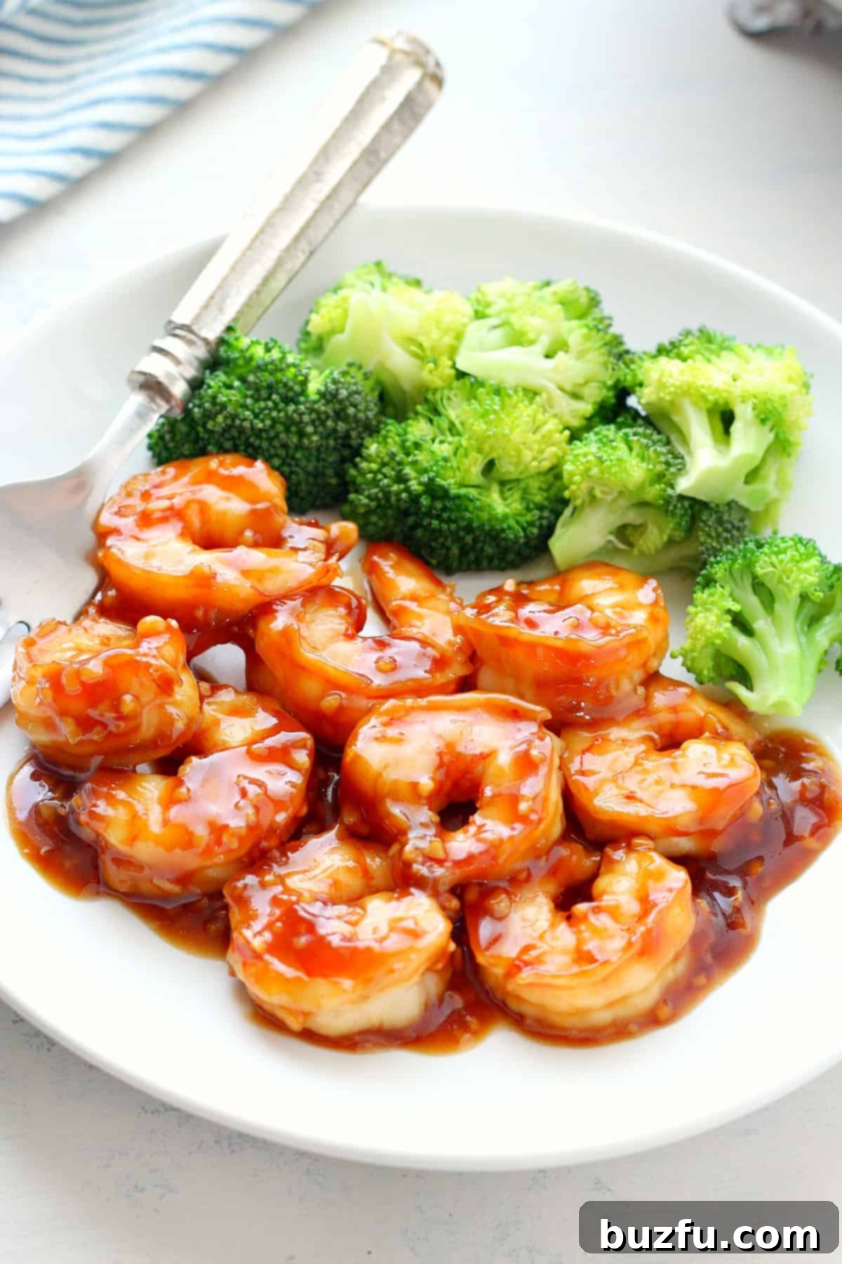 Shrimp with sauce and broccoli on a white plate, ready to be served.