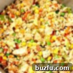 Chicken Fried Rice being cooked in a stainless steel skillet.