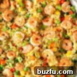 Shrimp Fried Rice cooking in a stainless steel skillet with mixed vegetables.