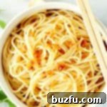 Garlic Noodles in a white bowl with chopsticks, ready to enjoy.