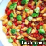 Vibrant Teriyaki chicken stir fry with mixed vegetables in a white skillet.