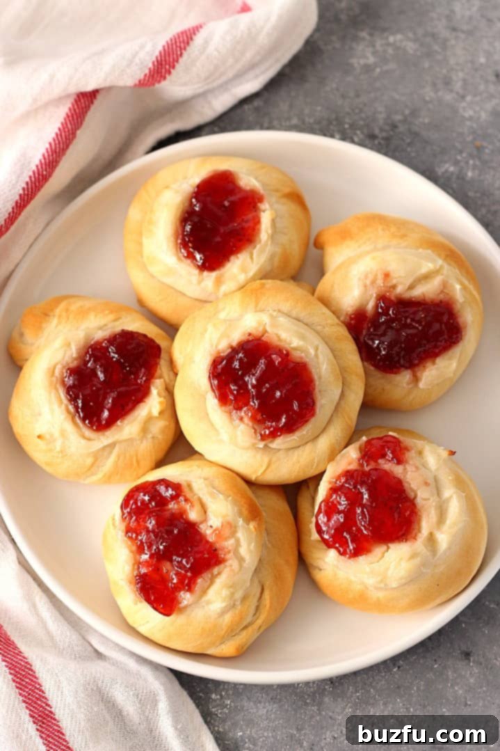 Easy Cream Cheese and Jam Danish Recipe - soft and fluffy pastry with creamy vanilla filling and sweet strawberry jam topping. www.crunchycreamysweet.com Close-up of an Easy Cream Cheese and Jam Danish, showcasing the fluffy pastry and sweet filling.