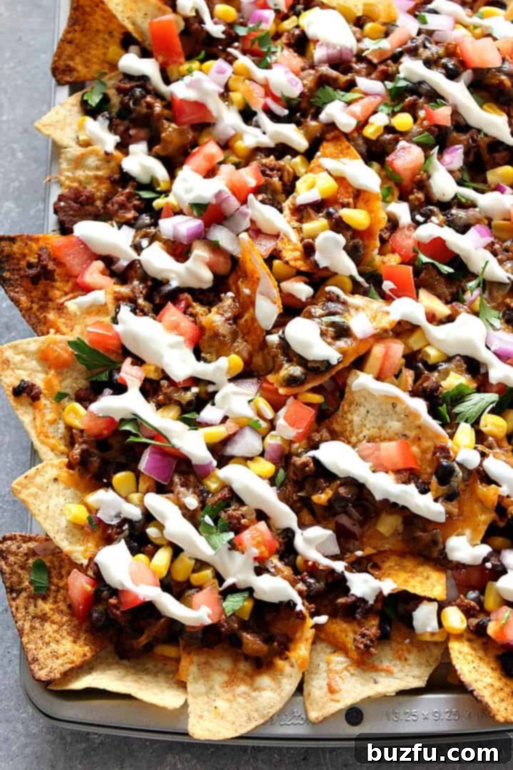 Delicious Sheet Pan Nachos loaded with toppings, fresh out of the oven.