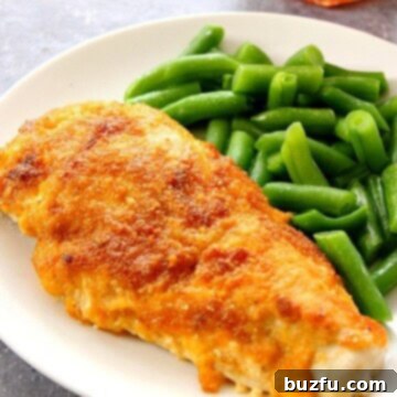 BBQ Cheddar Chicken on white plate, next to green beans.