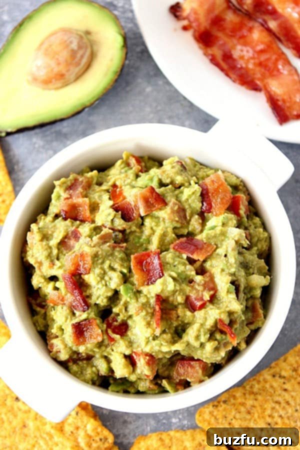Irresistible Bacon Guacamole Recipe Bacon guacamole in white serving bowl, ready to be devoured.