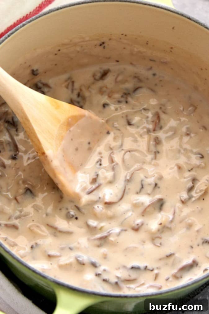 Craft Your Own Condensed Creamy Mushroom Soup 4 Cream of mushroom soup in a green Dutch oven on a gray board.