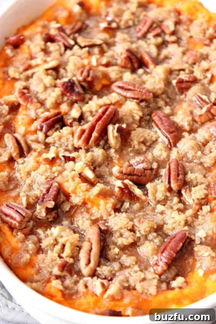 The Best Easy Sweet Potato Casserole Recipe - classic Thanksgiving holiday side dish made easy! www.crunchycreamysweet.com Close up on pecan and brown sugar topping on the sweet potato casserole.