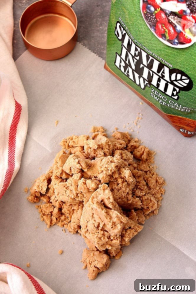 Unbaked shortbread cookie dough rolled out between two sheets of parchment paper.