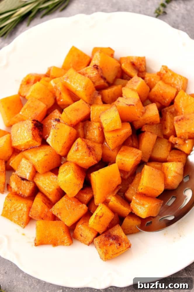 Close-up of roasted butternut squash on a white plate, highlighting its golden color.