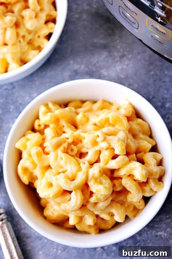 The best and easiest way to make macaroni and cheese in the Instant Pot. This recipe is 100% kid-approved. Overhead shot of mac and cheese in white bowl. A serving of golden, creamy macaroni and cheese, ready to eat.