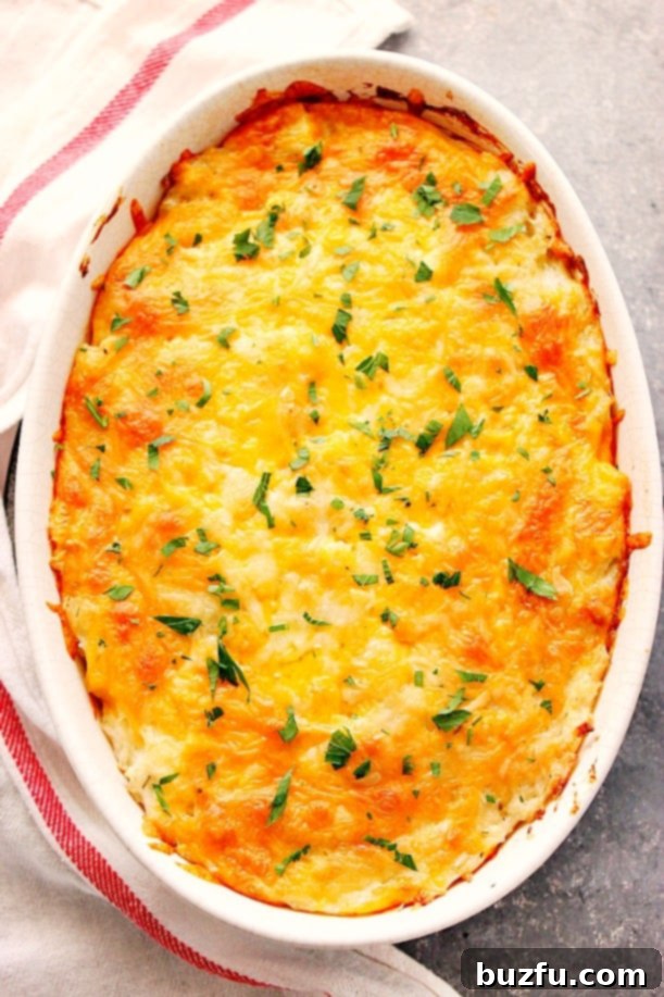 A bubbly, golden Hashbrown Casserole in a white oval baking dish, straight from the oven.