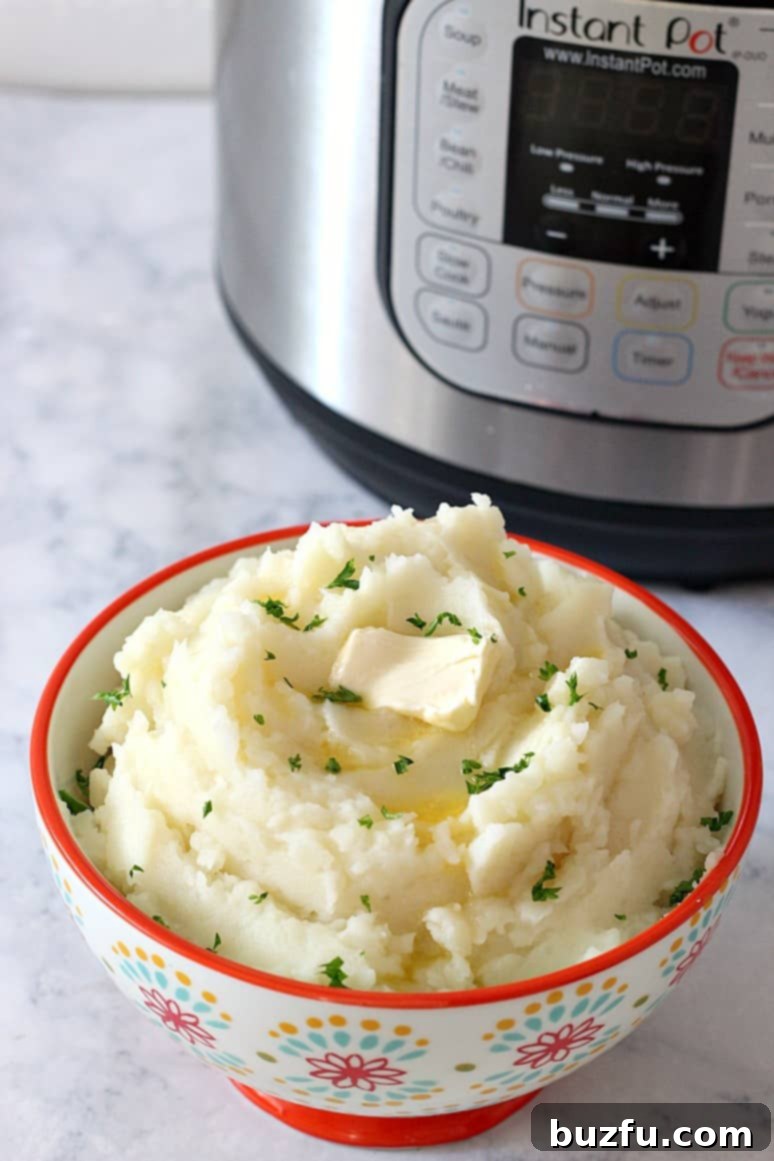 A vibrant bowl of fluffy Instant Pot mashed potatoes, ready to be served, with a hint of butter melting on top.
