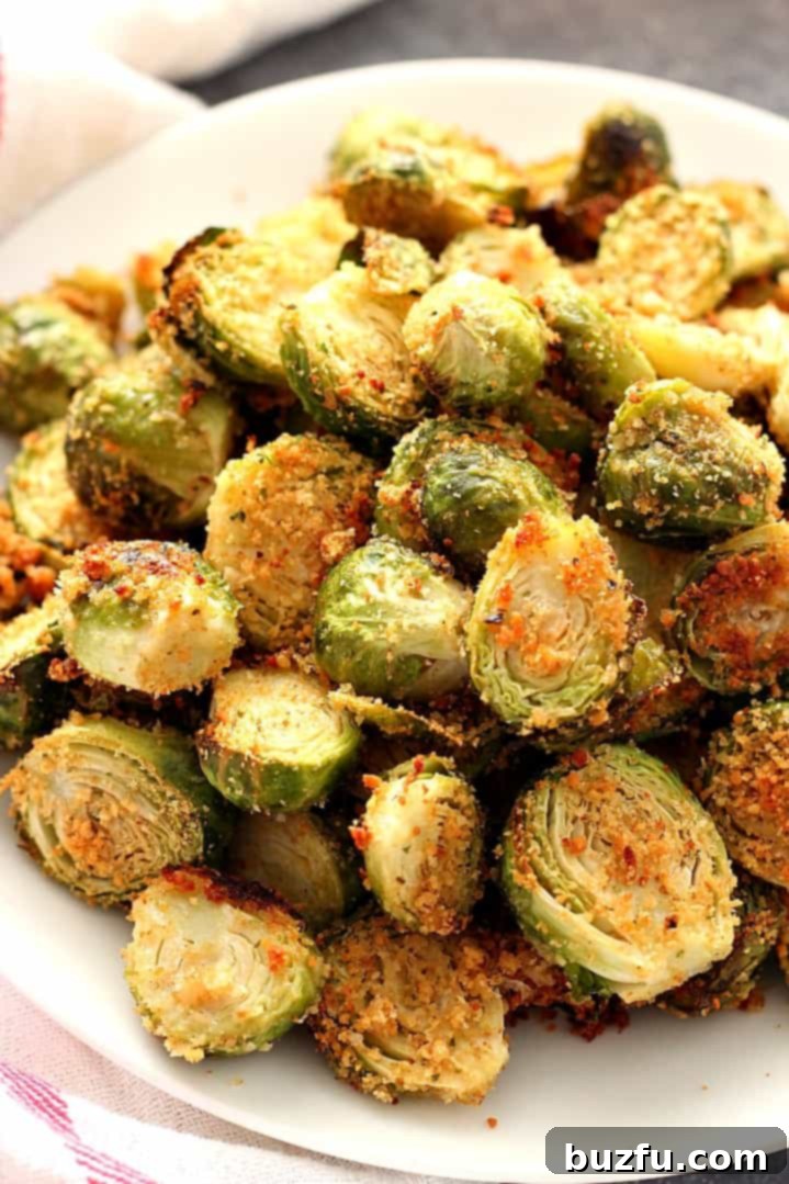 A close-up of golden-brown garlic Parmesan roasted Brussels sprouts, garnished with fresh herbs.