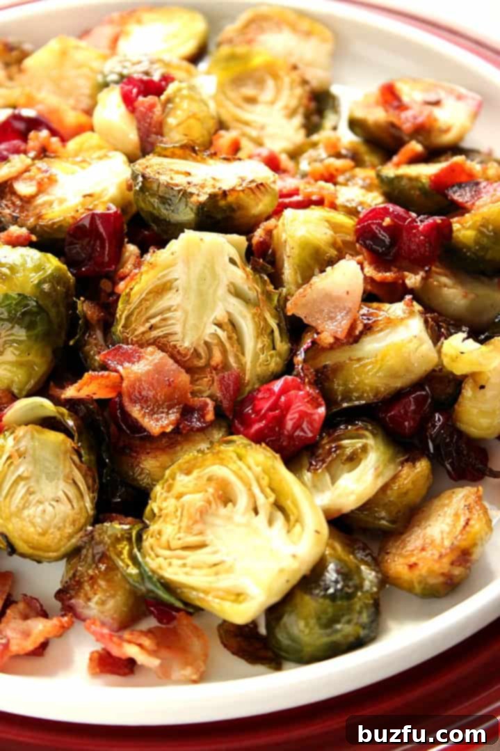 A colorful dish of roasted Brussels sprouts, crispy bacon, and bright red cranberries, ready to serve.