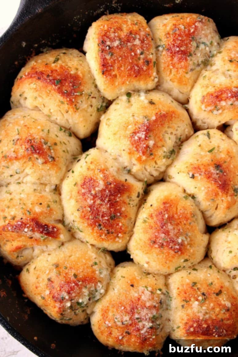 Golden-brown Garlic Parmesan Skillet Rolls, fresh from the oven, served in a cast iron skillet.