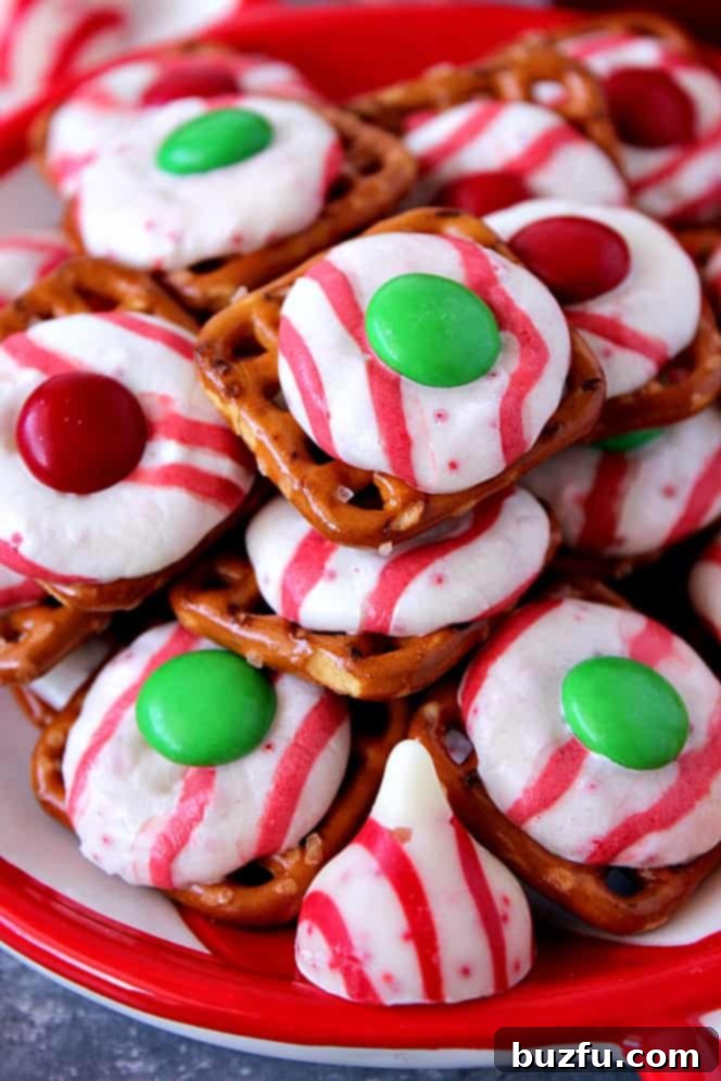 Easy Peppermint Pretzel Bites Peppermint Pretzel Candy recipe - crunchy pretzels topped with peppermint Kisses candy and M&M's makes for a festive holiday treat that is fun to make and eat!