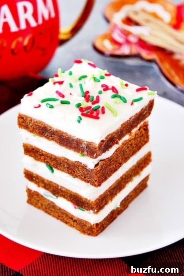 Gingerbread Bars with frosting stacked on white plate.