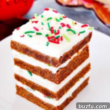 Gingerbread Bars with frosting stacked on white plate.