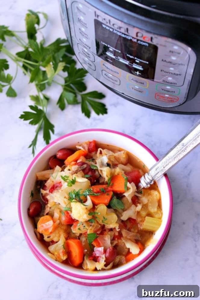 Overhead shot of a full bowl of Instant Pot vegetable soup, placed next to the Instant Pot cooker itself, signifying a freshly made meal.