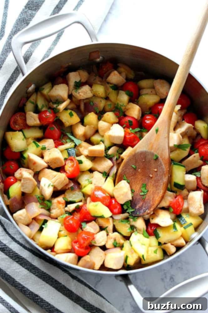 Sizzling chicken and vibrant vegetables cooking together in a cast iron skillet