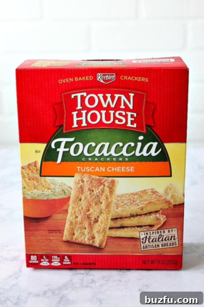 A box of Town House Focaccia Crackers in Tuscan Cheese flavor, displayed alongside a bowl of dip, ready for snacking.