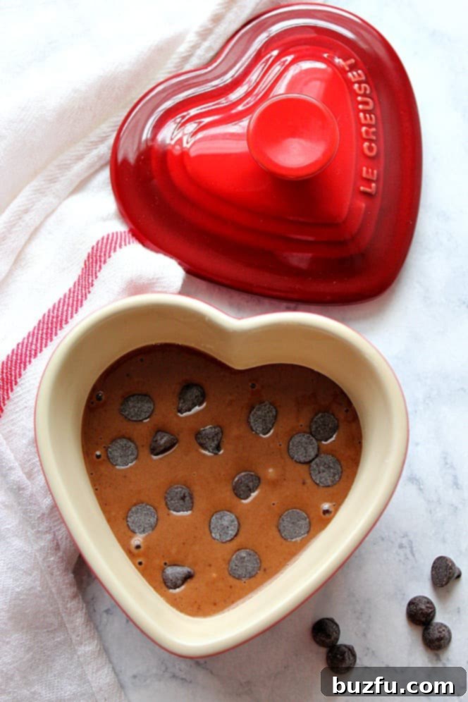 Heart-shaped ramekin filled with rich chocolate mug cake batter, ready for the microwave.