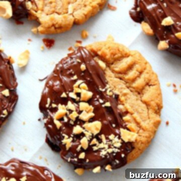 Peanut butter cookies on a parchment paper-lined baking sheet, freshly baked.