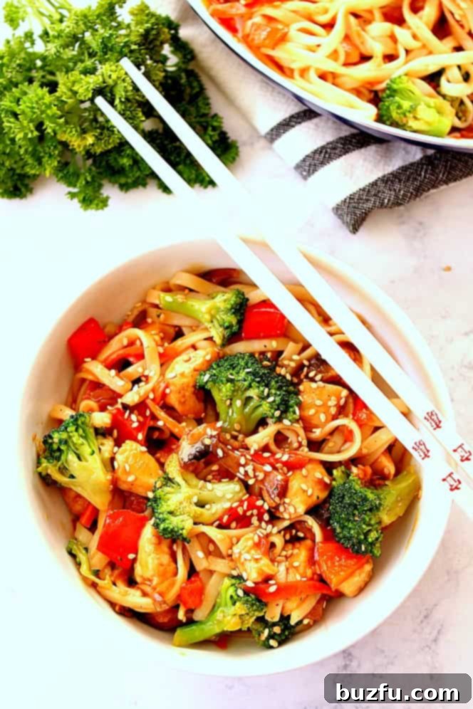 chicken stir fry in bowl with chopsticks