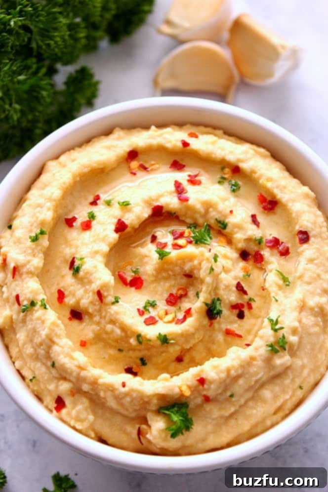 Easy Hummus without Tahini - simple recipe for hummus made with just a few ingredients and no tahini. So much better than store-bought stuff. Creamy homemade hummus without tahini in a decorative bowl, ready to be served as a healthy dip or spread.