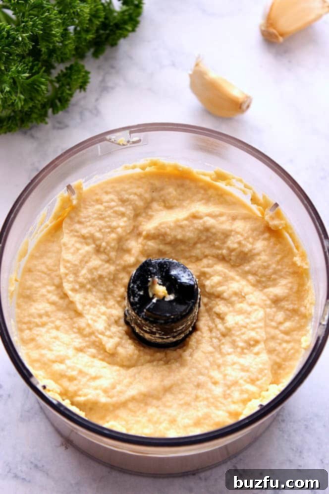 Easy Hummus without Tahini - simple recipe for hummus made with just a few ingredients and no tahini. So much better than store-bought stuff. Food processor blending fresh chickpeas, garlic, and lemon juice into a creamy homemade hummus.