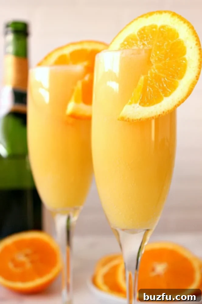 orange mimosa with a slice of orange in champagne flute