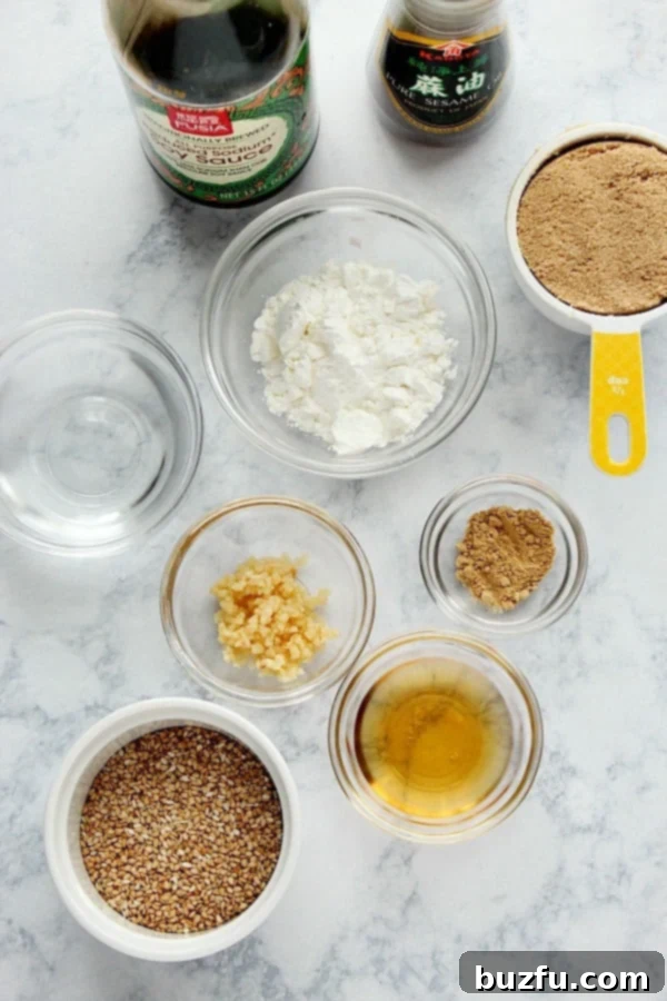 What is teriyaki sauce made of? Teriyaki sauce ingredients in glass bowls and bottles on a marble board.