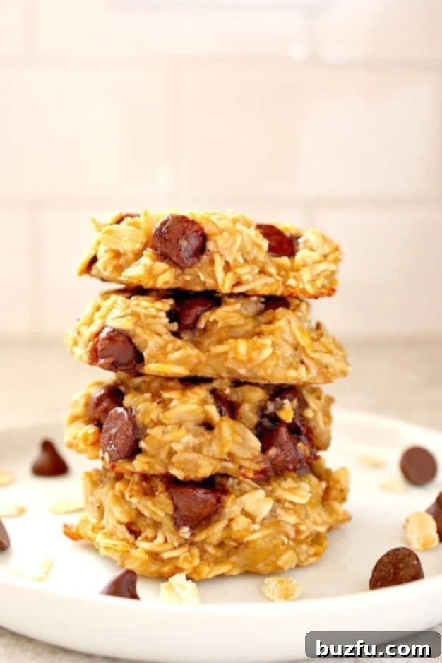 3 Ingredient Oatmeal Chocolate Chip Cookies Recipe - healthy cookies made with sweet ripe bananas, oats and chocolate chips. No sugar, eggs, flour or oil added! Stacked oatmeal cookies with chocolate chips on a white plate
