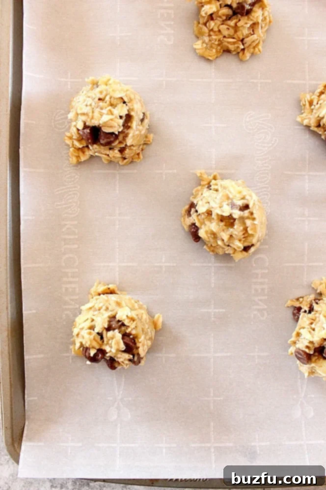 3 Ingredient Oatmeal Chocolate Chip Cookies Recipe - healthy cookies made with sweet ripe bananas, oats and chocolate chips. No sugar, eggs, flour or oil added! Scooped oatmeal cookies on parchment paper-lined baking sheet