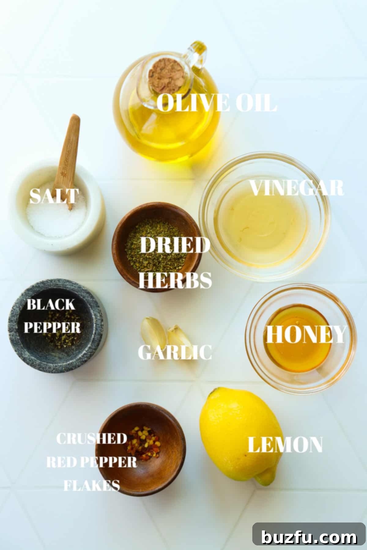 Zesty Italian Dressing 3 All essential ingredients for homemade Italian dressing displayed neatly in small bowls on a clean white tile board, ready for mixing.