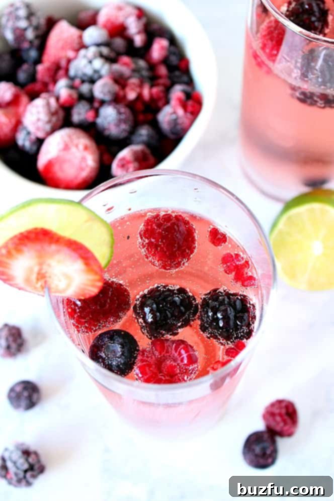 Overhead shot of berry sangria in glass with slice of strawberry and lime.