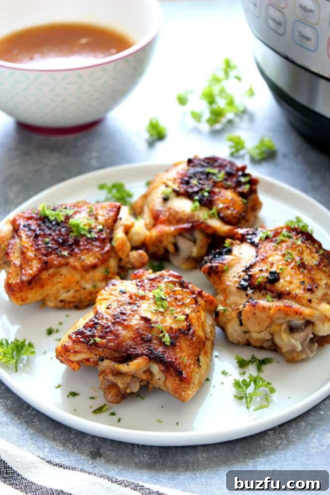 Side shot of roasted chicken thighs on white plate. 