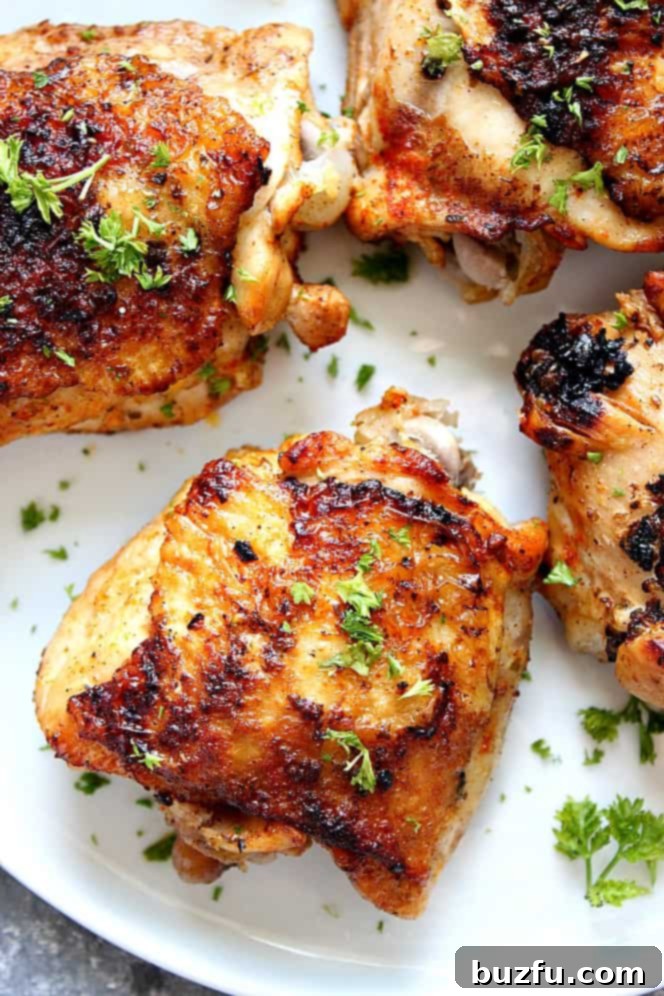 Instant Pot Chicken Thighs with crispy skin, on white plate.