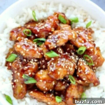 Chicken with sesame sauce on rice in a bowl.