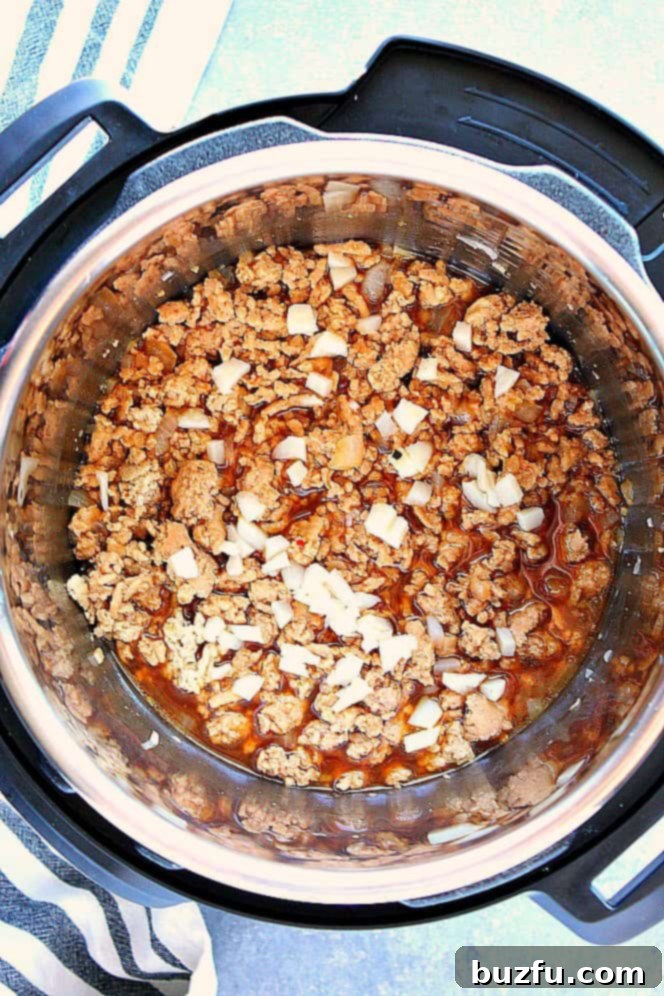 Overhead shot of ground chicken with chopped water chestnuts stirred into the Instant Pot, ready to be served.
