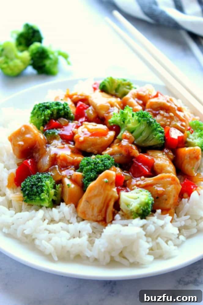 Close-up side view of a plate featuring Teriyaki Chicken Stir Fry with bright green broccoli over white rice.