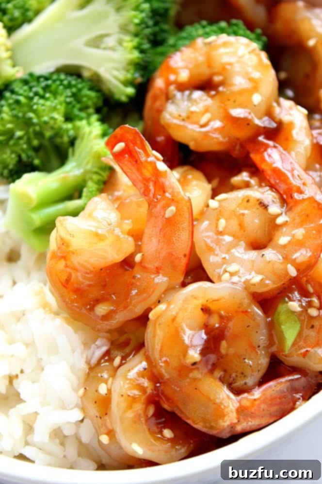 10-Minute Teriyaki Shrimp Recipe - quick and easy seafood takeout dinner that's healthy and delicious. Close up on teriyaki shrimp with tails next to rice and broccoli.