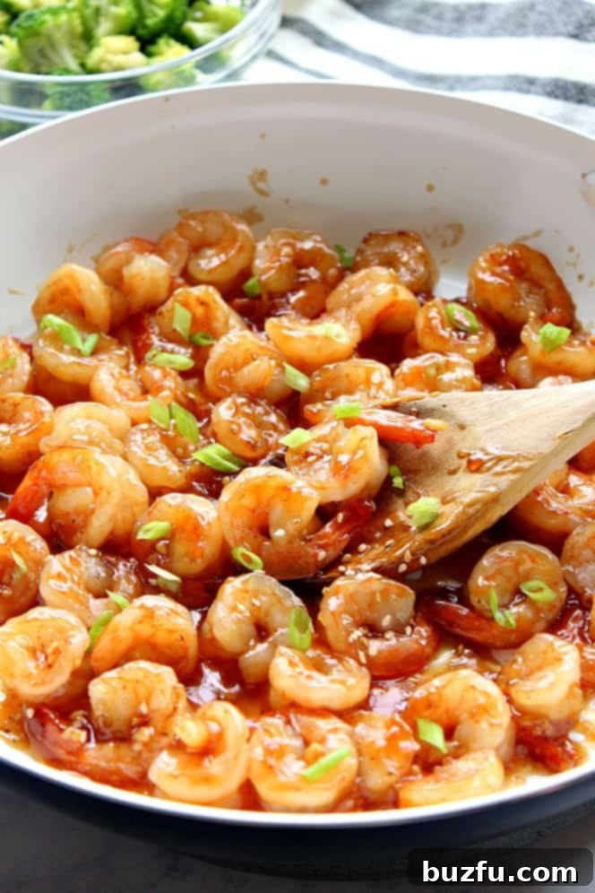 10-Minute Teriyaki Shrimp Recipe - quick and easy seafood takeout dinner that's healthy and delicious. Side shot of teriyaki shrimp in white skillet.